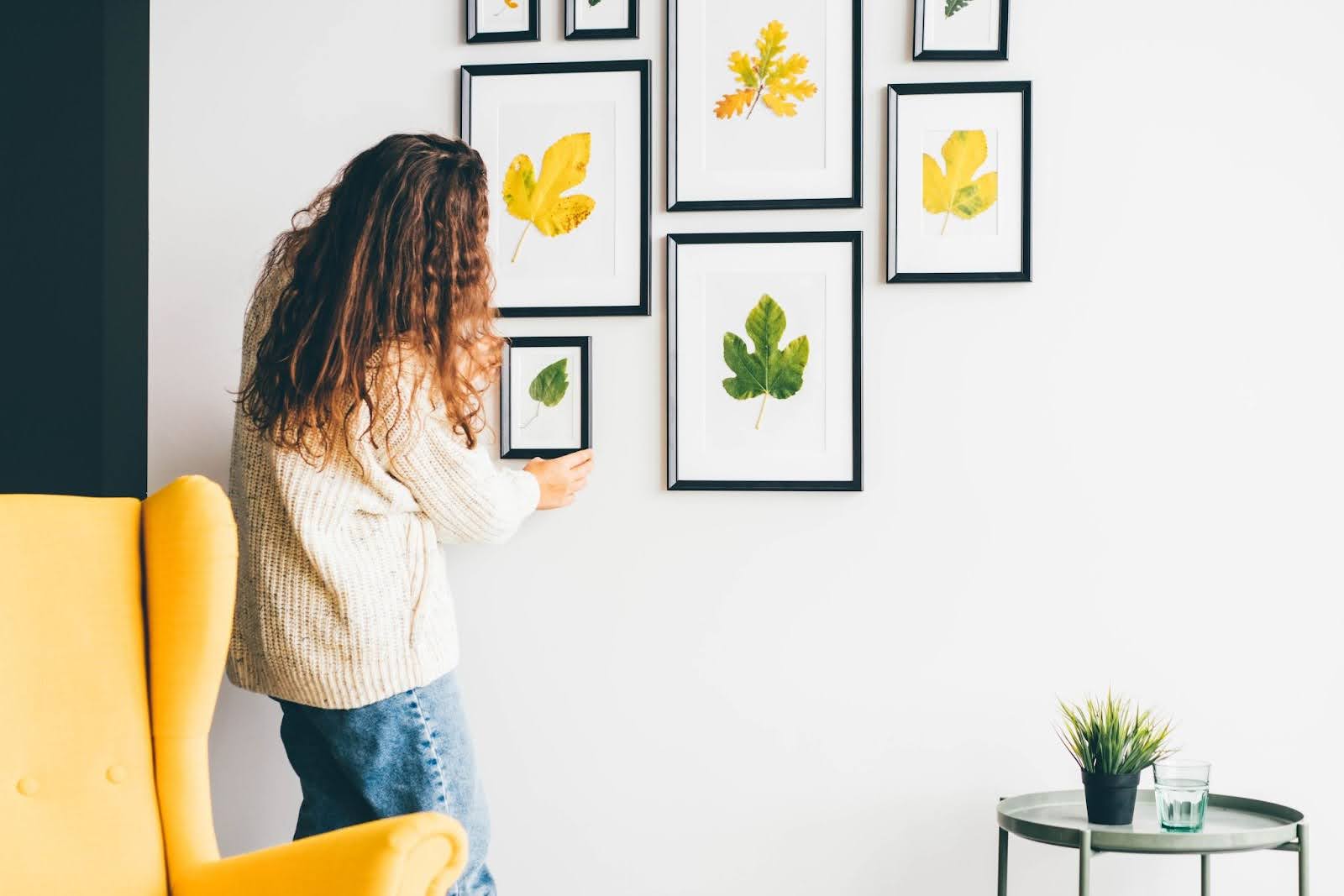 Woman hanging a gallery wall at her home